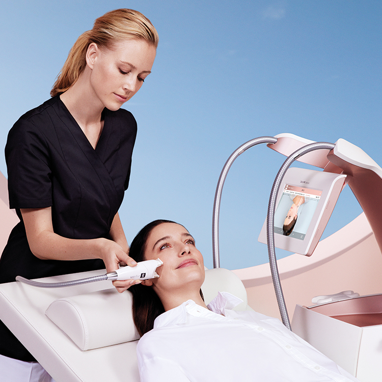 Esthéticienne procurant un soin endermologie® esthétique sur le bas du corps d'une patiente